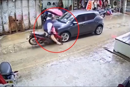 Clip: Cầm ô chạy xe máy giữa mưa, thanh niên lao thẳng vào ô tô đối diện