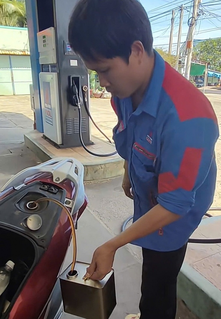 Hình ảnh nhân viên cửa hàng hút lại toàn bộ số xăng đã bơm vào xe máy của khách. Ảnh cắt từ clip