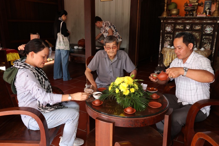 Chủ nhà mời trà tiếp các vị khách đến thăm.