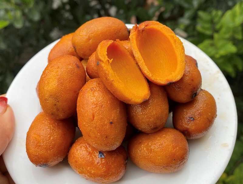 Bên trong lớp vỏ đen sì là lớp thịt vàng ươm, béo ngậy của quả cọ ngon. (Ảnh: Hải Yến).