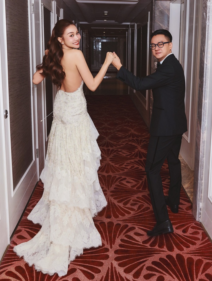 Bộ đầm ren xếp tầng, hở lưng giúp Thanh Hằng khoe vẻ sexy khi sánh đôi chồng nhạc trưởng.