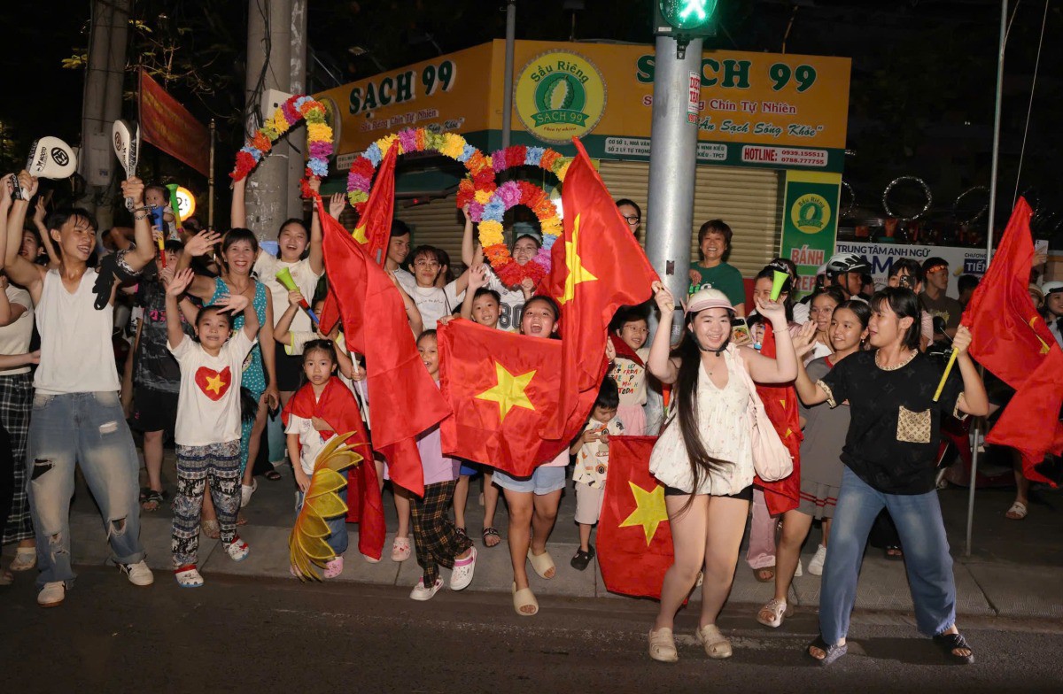 Người dân Cần Thơ mang theo cờ tổ quốc ra đường ăn mừng huy chương vàng bóng đá nam. Ảnh: Huy Phong