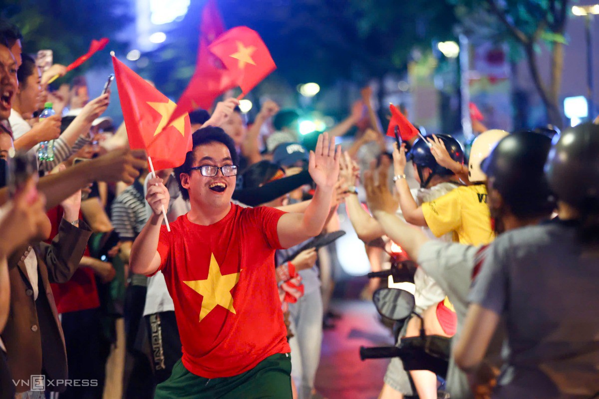 Lưu Hoàng Đạt (25 tuổi) hân hoan bắt tay mọi người đi đường. "Một năm rồi người dân thành phố lại được ra đường đi bão, thành tích tuyệt vời của thầy Kim". Ảnh: Quỳnh Trần