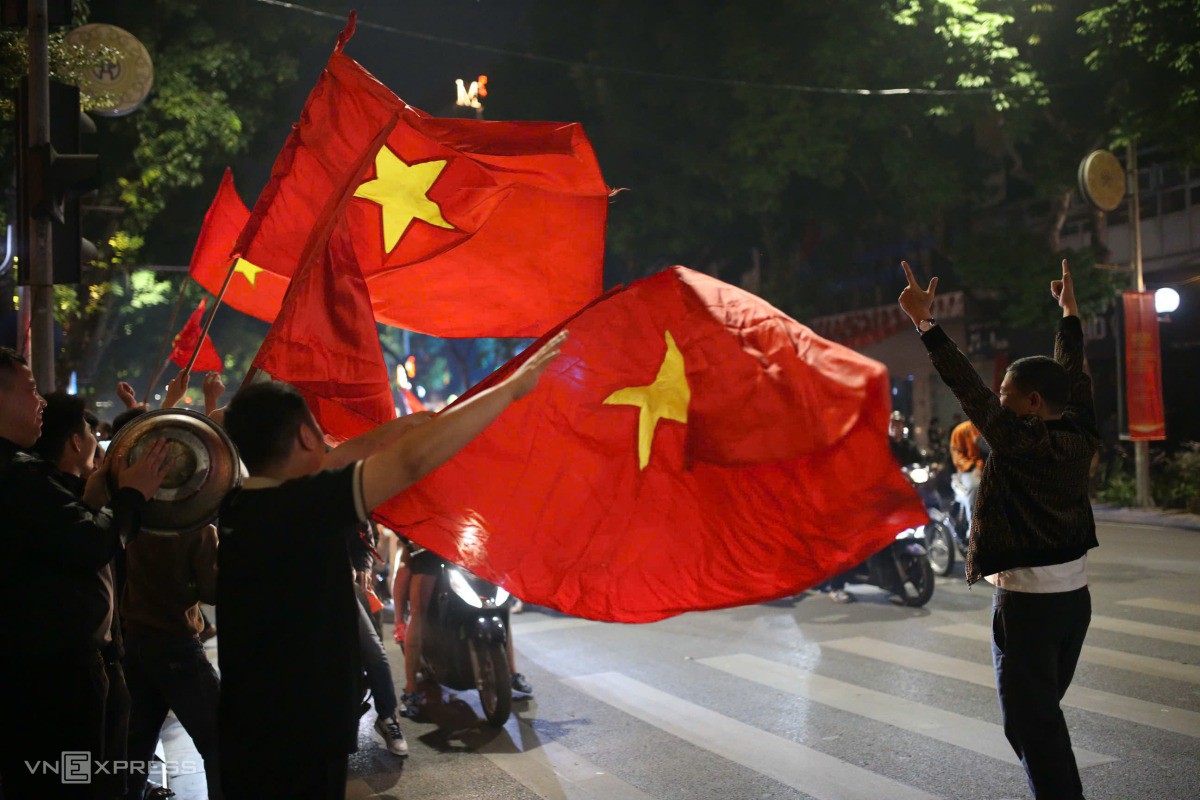 Trên khắp tuyến phố hướng về trung tâm Hà Nội, người dân cầm cờ, mang nồi đi gõ để ăn mừng. Ảnh: Phạm Chiểu