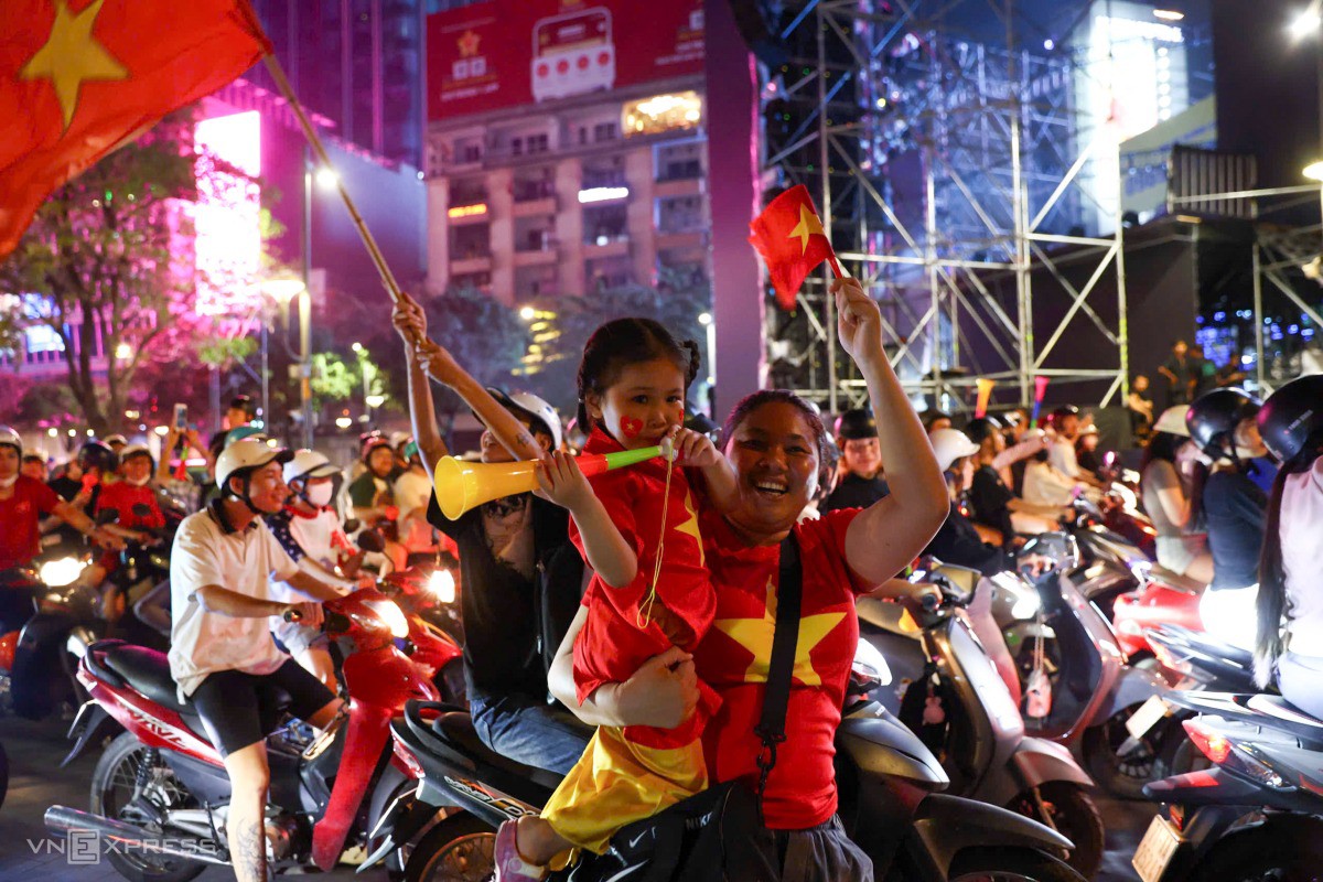 Em nhỏ được mẹ bế xuống đường Nguyễn Huệ cổ vũ. Ảnh: Quỳnh Trần