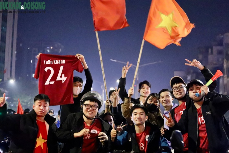 Một nhóm bạn trẻ vừa kết thúc trận bóng đá cũng hòa vào dòng người ăn mừng trên đường phố.