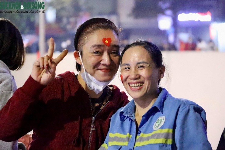 Giữa dòng người ăn mừng rộn ràng, những công nhân vệ sinh vẫn lặng lẽ làm việc, đồng thời tranh thủ nở nụ cười và ghi lại khoảnh khắc đáng nhớ của một đêm Hà Nội không ngủ.