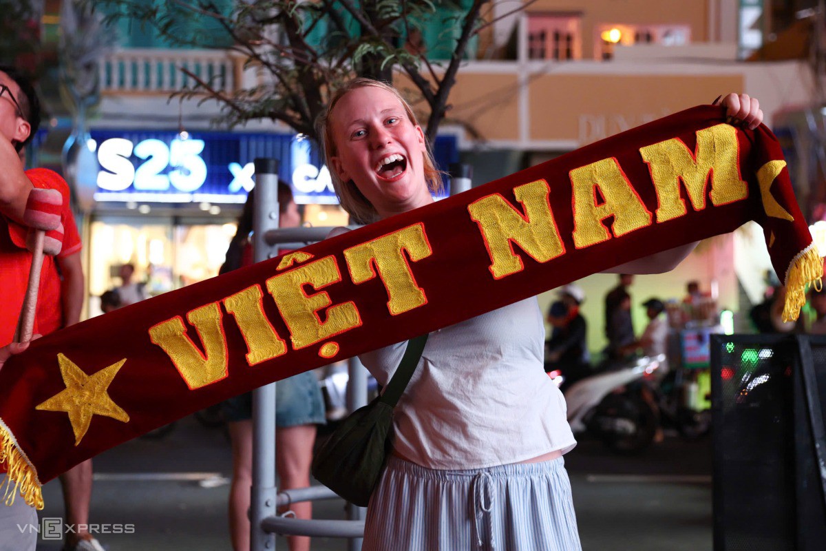 Nữ du khách căng băng rôn Việt Nam mừng chiến thắng của đội tuyển. Ảnh: Quỳnh Trần