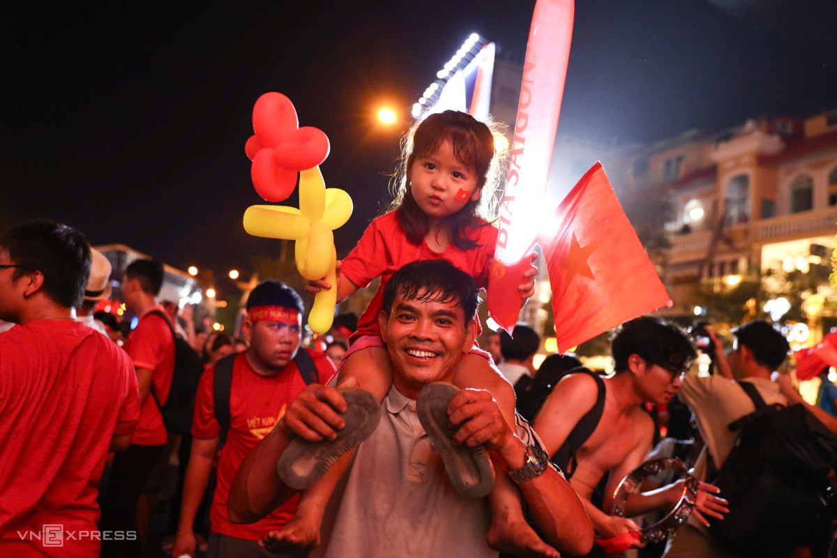 Cha cõng con cùng ăn mừng chiến thắng của đội tuyển. Ảnh: Quỳnh Trần