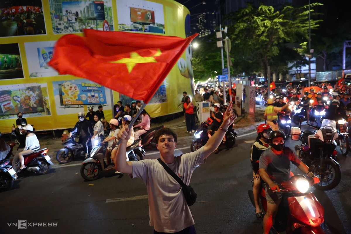 Du khách nước ngoài cầm cờ Việt Nam khuấy động không khí. Ảnh: Quỳnh Trần