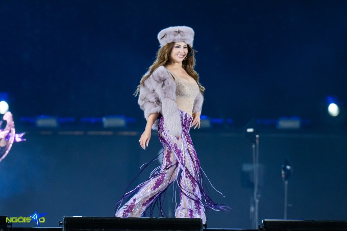 Nữ ca sĩ khoe dáng sexy với quần ống loe, áo không tay chất liệu xuyên thấu đính sequin và áo choàng lông màu đồng điệu.