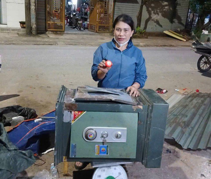 Chị Hương bên chiếc két sắt cũ và số vàng được phát hiện (Ảnh Công an cung cấp)