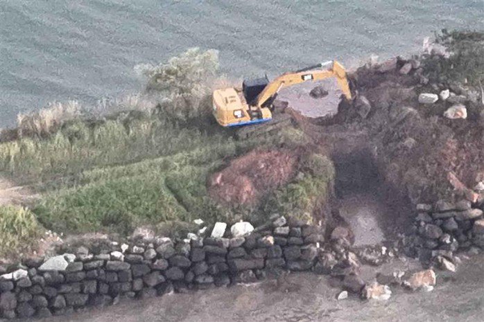 Máy xúc đang dỡ bỏ đê chắn sóng ở tỉnh Koh Kong - Campuchia. Ảnh: Bangkok Post