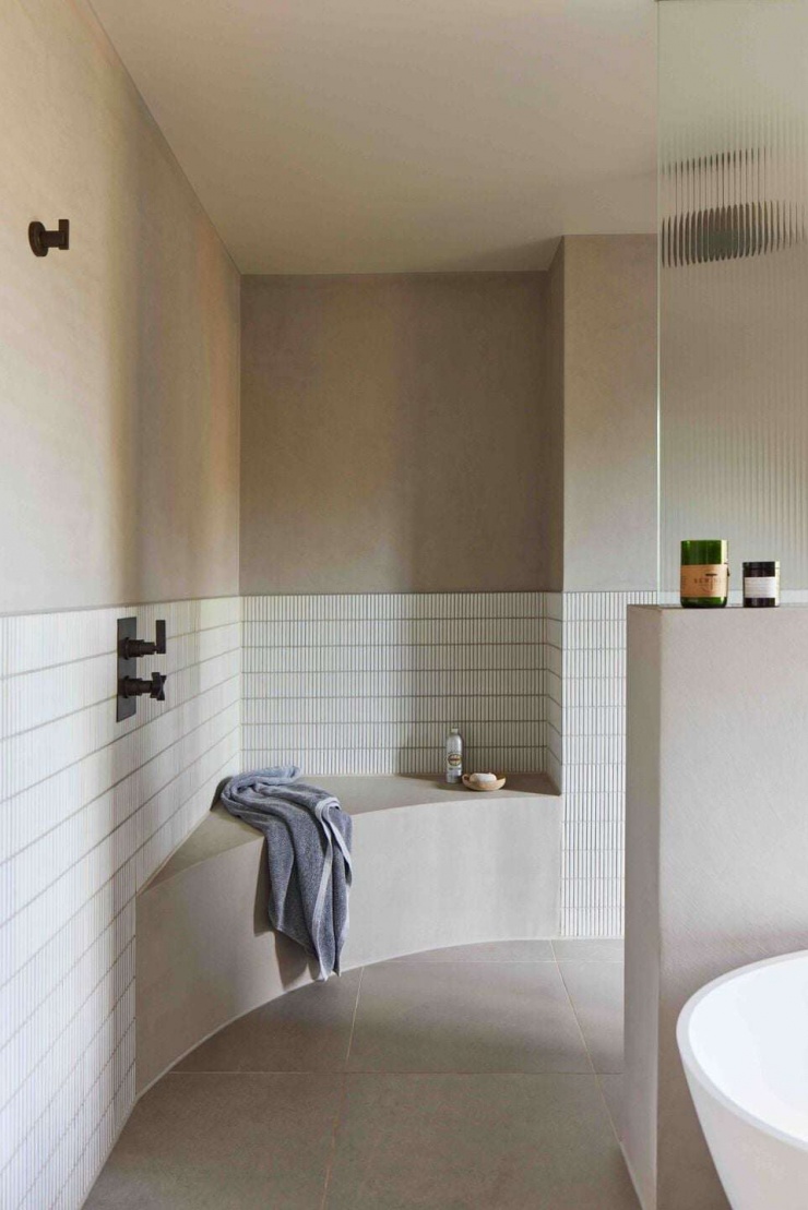 Khu vực tắm được bo cong mềm mại, kết hợp gạch thẻ sáng màu và bề mặt hoàn thiện mịn. Thiết kế bo tròn giúp không gian trở nên nhẹ nhàng, an toàn và dễ chịu khi sử dụng hằng ngày