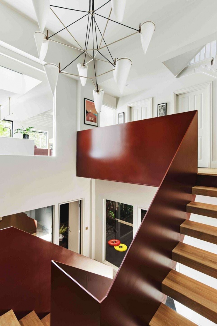 Cầu thang thép màu gỉ được thiết kế như một điểm nhấn điêu khắc trong không gian nhà. Việc đặt cầu thang quanh lõi thông tầng giúp ánh sáng lan tỏa đều xuống các tầng dưới