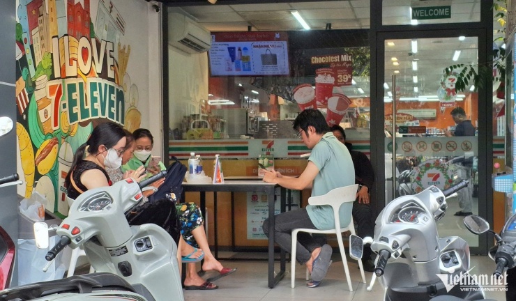 Người dân ngồi ở cửa hàng tiện lợi để đăng ký mua vàng miếng SJC trực tuyến. Ảnh: T.C