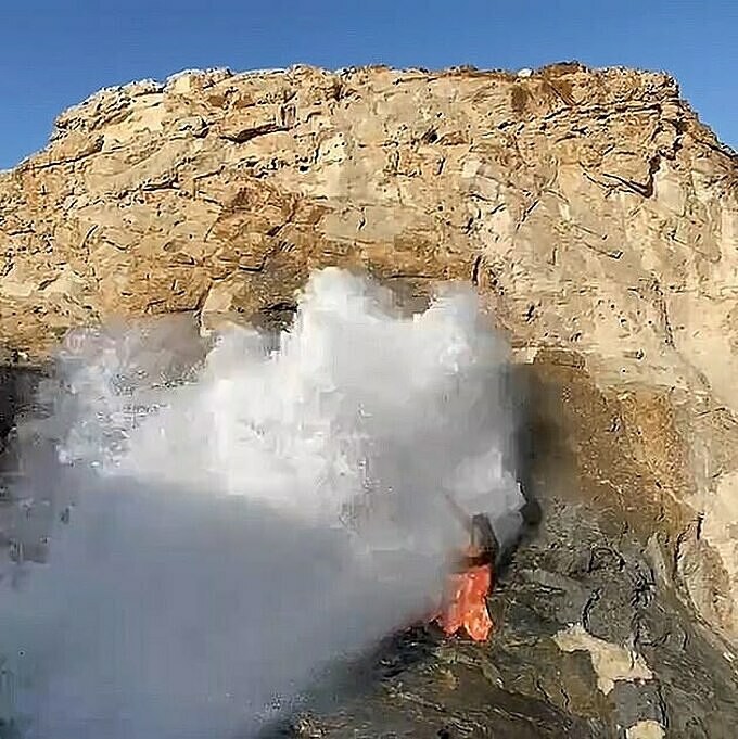 Cơn sóng lớn bất ngờ đánh văng nữ du khách xuống biển. Ảnh: Newsx