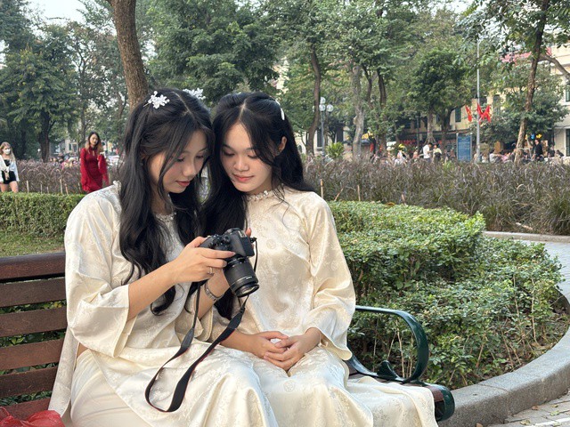 Khánh Trân cùng bạn xem lại ảnh áo dài vừa chụp (Ảnh: Nhật Anh).