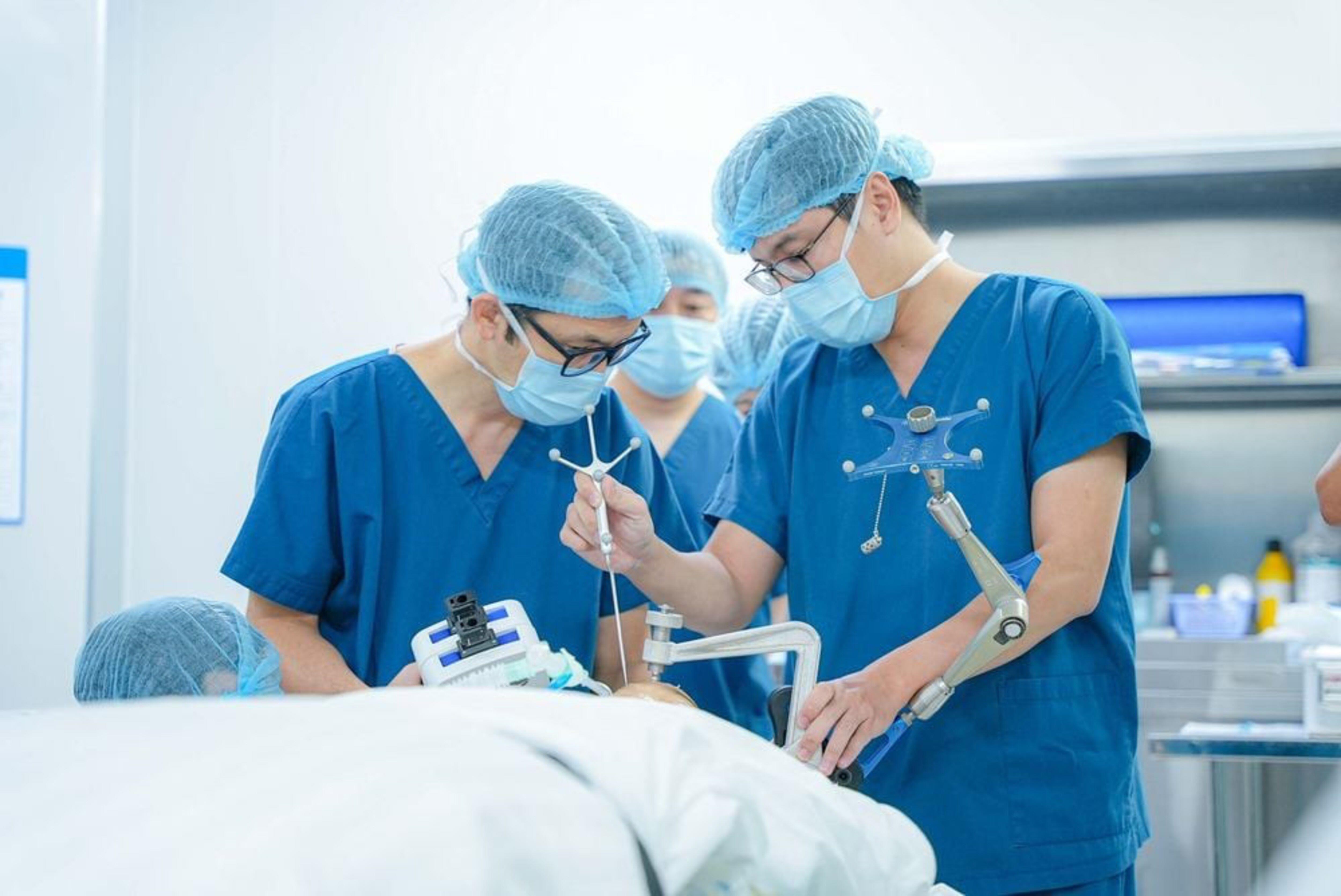  Ê-kíp bác sĩ đang chuẩn bị đưa điện cực vào sọ não, điều trị cho bệnh nhân 9 tuổi mắc động kinh kháng trị.