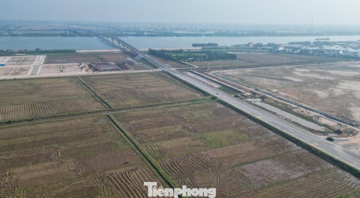 Từ trên cao, cầu vượt sông Hồng nổi bật giữa không gian cửa sông rộng lớn, bên dưới là vùng bãi bồi, đầm nuôi thủy sản và các khu sản xuất nông nghiệp ven sông.