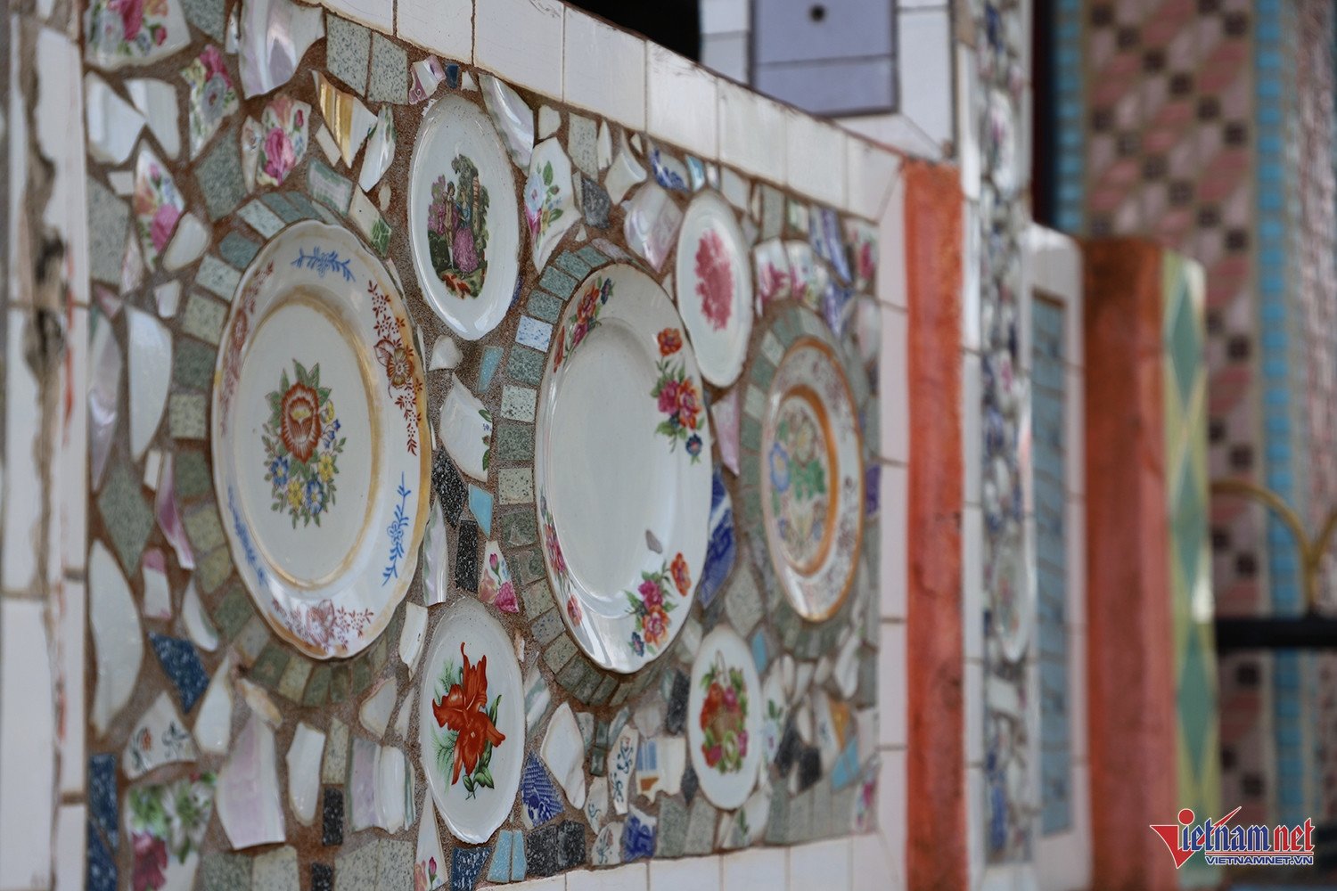 Các mảng tường, hàng rào được ốp bằng những mảnh chén, đĩa vỡ, gạch men với đủ màu sắc