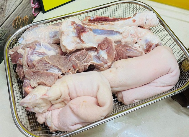 Dùng hỗn hợp rượu và nước xát sơ khắp chân giò để khử mùi, ngâm khoảng 5 phút rồi để ráo. Tách riêng da và thịt, da ngâm trong nước muối loãng 10 phút, rửa sạch, để ráo. Thịt cắt nhỏ, ướp với 1 muỗng cà phê hạt nêm, 1 muỗng cà phê tiêu xay, xoa đều và để 10 phút. Ảnh: Thanh Huệ