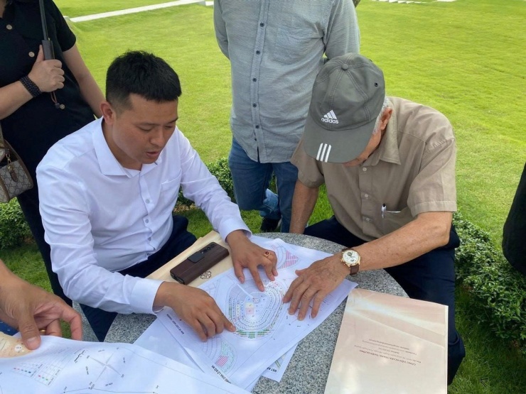 Anh Huy (áo trắng) tư vấn đất mộ cho khách. Không gian xanh mát, cảnh quan đẹp... khiến khách hàng thấy thoải mái khi đi xem. Ảnh: Nhà Ở Ngay RECO