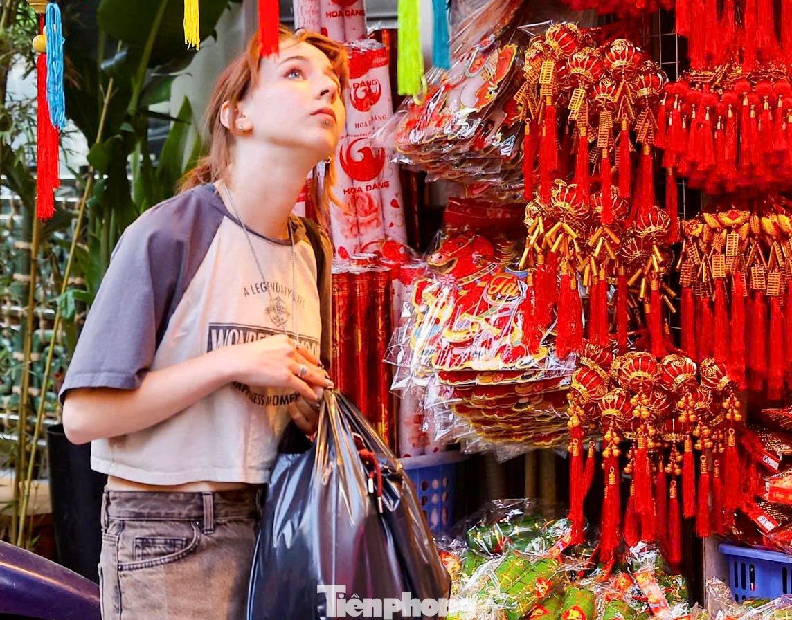 Du khách nước ngoài thích thú dạo phố, chụp ảnh và mua đồ trang trí Tết tại phố Hàng Mã.