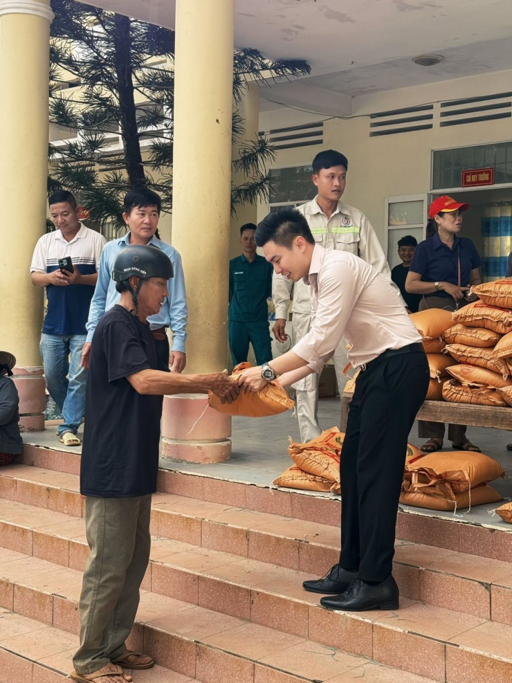 Viết Vương giữ nguyên "cây" trang phục văn phòng và nhiệt tình khuân vác, tặng nhu yếu phẩm cho đồng bào.