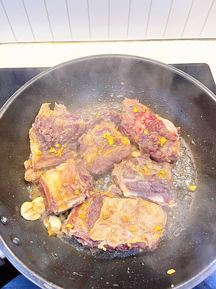 Sườn bò ướp xong cho lên chảo xào sơ cho ngấm gia vị, sau đó cho kim chi vào xào cùng