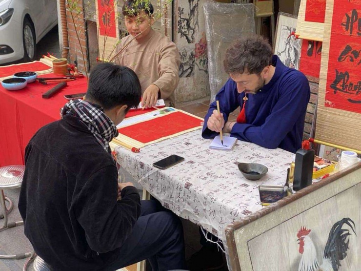 Du khách học viết chữ Nho tại Văn Miếu Quốc Từ Giám năm 2025. (Ảnh: Huy Hoàng)