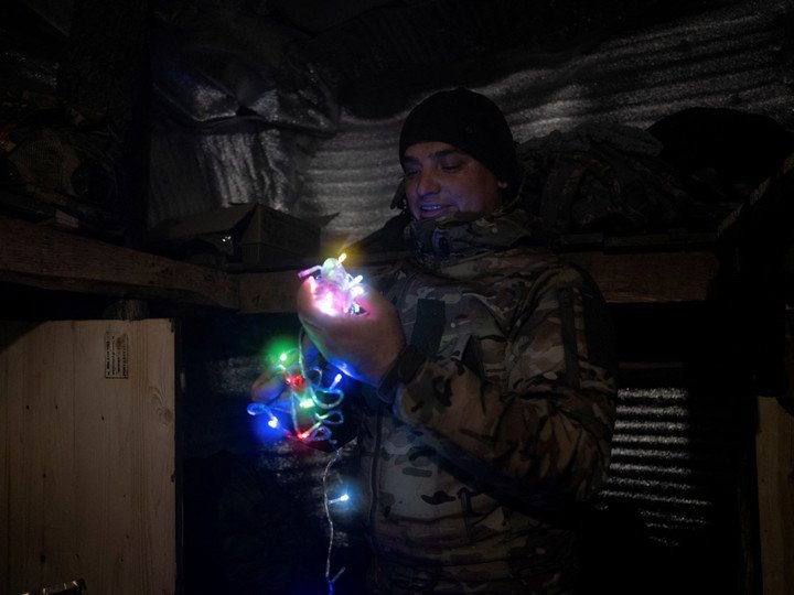 Một binh sĩ Ukraine trang trí hầm trú ẩn bằng đèn đón năm mới tại một vị trí gần thị trấn tiền tuyến Kostiantynivka. (Ảnh: Reuters)