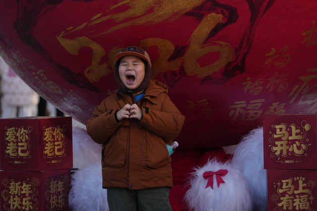 Một em bé tạo dáng với tiểu cảnh trang trí năm mới tại Bắc Kinh - Trung Quốc hôm 31-12 - Ảnh: AP