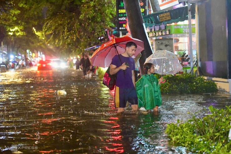 Cách đường Nguyễn Hữu Cảnh gần 2 km, mưa ngập gần một mét trên đường Quốc Hương (quận 2 cũ) khiến nhiều xe chết máy, người dân phải gọi cứu hộ, dắt bộ. Nằm gần sông Sài Gòn nên đây là một trong rốn ngập ở thành phố.