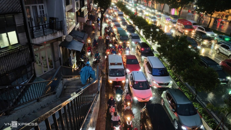 Dòng xe bật đèn kéo dài trên đường cửa ngõ ra vào sân bay Tân Sơn Nhất.