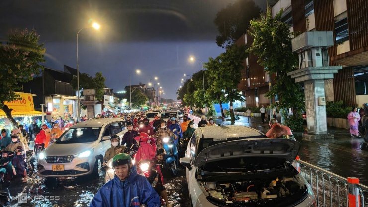 Dòng xe đứng im trên cầu vượt từ Công viên Gia Định về đường Nguyễn Thái Sơn, khu vực Gò Vấp cũ. Một ôtô chết máy giữa đường, chiếm một làn khiến giao thông càng ùn ứ.