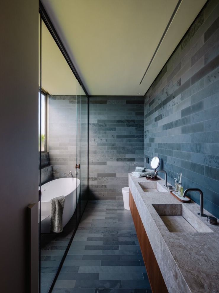 Hai phòng tắm sử dụng đá ở khu vực lavabo, kết hợp tủ gỗ bên dưới.