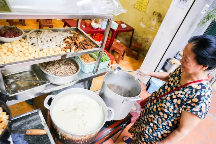 Bánh đúc nóng Bánh đúc nóng có thành phần chính là bột gạo, nấu cho đến khi đặc lại, sền sệt, phần nhân làm từ thịt và mộc nhĩ băm nhuyễn. Khi khách ăn, người bán múc bánh, thêm nhân, chan nước dùng xương nóng và rắc hành khô, hành lá. Mỗi suất thường có giá từ 25.000 đồng. Ảnh: Xuân Phương