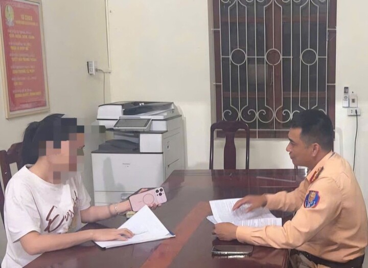 Cán bộ Phòng CSGT Công an tỉnh Thanh Hoá làm việc, lập biên bản vi phạm hành chính với chị H.T.H. (Ảnh: Công an Thanh Hoá)