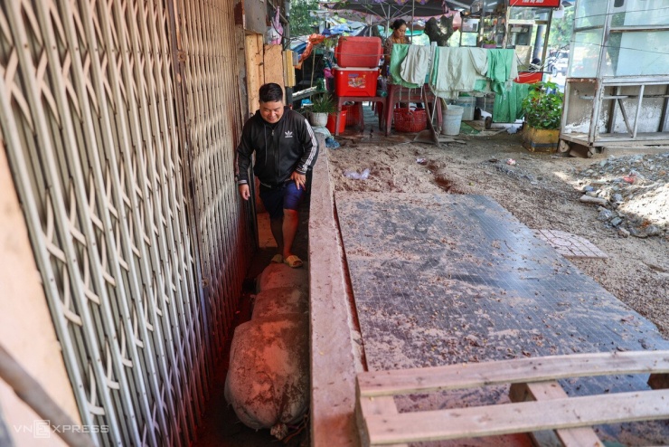 Hàng loạt căn nhà rơi vào cảnh thấp hơn mặt đường 1-1,5 m sau khi tuyến Đặng Thùy Trâm được nâng nền. Nhiều căn lọt thỏm dưới bức tường, khiến khoảng sân trước bị thu hẹp. Người dân phải tận dụng ghế, xô, bao cát làm bậc tạm để ra vào.