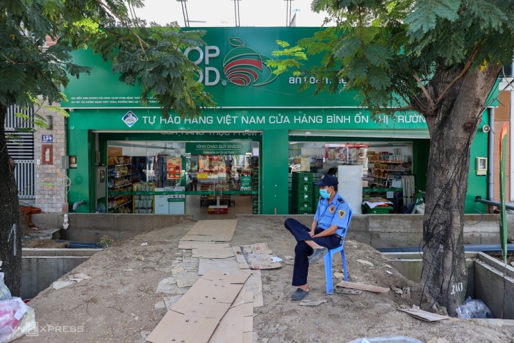 Gần đó, một siêu thị cũng nằm thấp hơn mặt đường, phải làm bậc tam cấp, đắp đất và lót bìa carton tại lối vào. Việc vận chuyển hàng hóa trở nên bất tiện do mặt đường ngổn ngang vật liệu xây dựng.