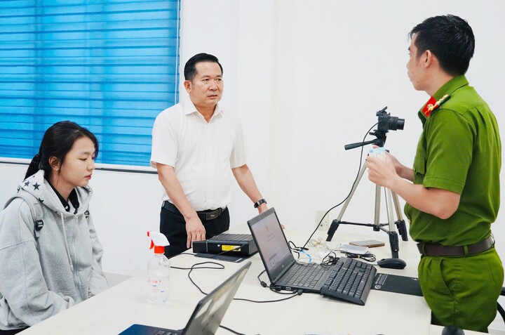 Ông Đinh Văn Nơi thăm hỏi cán bộ công an về việc cấp căn cước cho người dân. (Ảnh: Dung Hoàng).