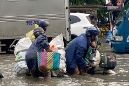 Người và xe ngã nhào trên đường phố ngập sâu ở TPHCM