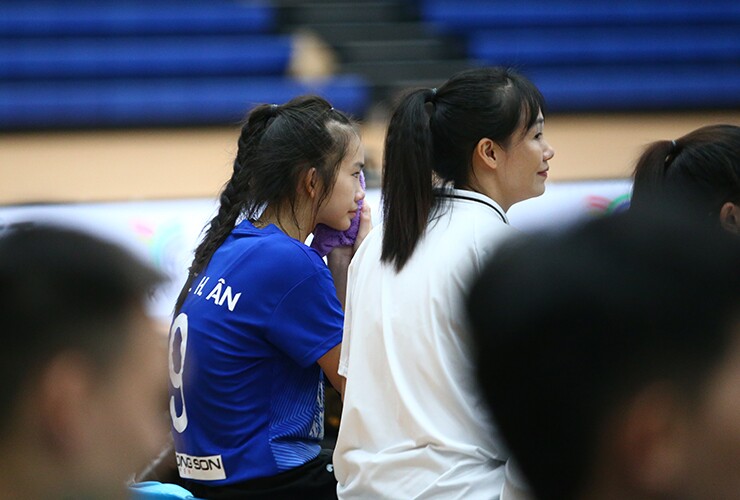 Trên băng ghế dự bị, nữ libero sinh năm 2012 vừa chườm khăn vừa bật khóc nức nở. Một bên mặt và vùng mắt của cô sưng to sau cú bóng mạnh.