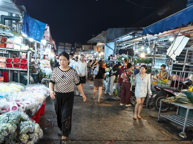 Người mua bán qua lại giữa các quầy hoa tại chợ Quảng An