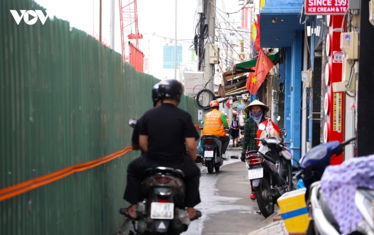 Phía sau hàng rào công trường, người dân và các hộ kinh doanh tìm cách thích nghi với những thay đổi trong việc đi lại, buôn bán.