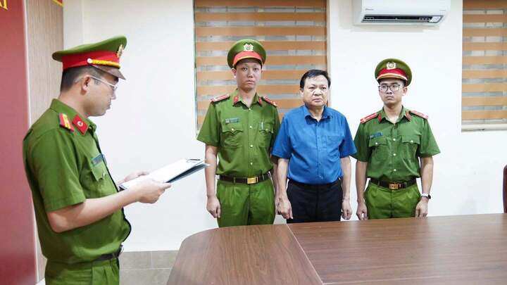 Cơ quan CSĐT đọc quyết định khởi tố bị can đối với ông Hoàng Văn Lộc, Bí thư Đảng ủy, Chủ tịch HĐND xã Hợp Kim. (Ảnh: CAPT)