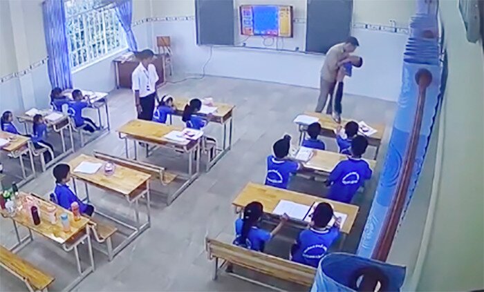 Giáo viên người Nga nhấc bổng một học sinh, đưa ra khỏi lớp học. Ảnh cắt từ clip